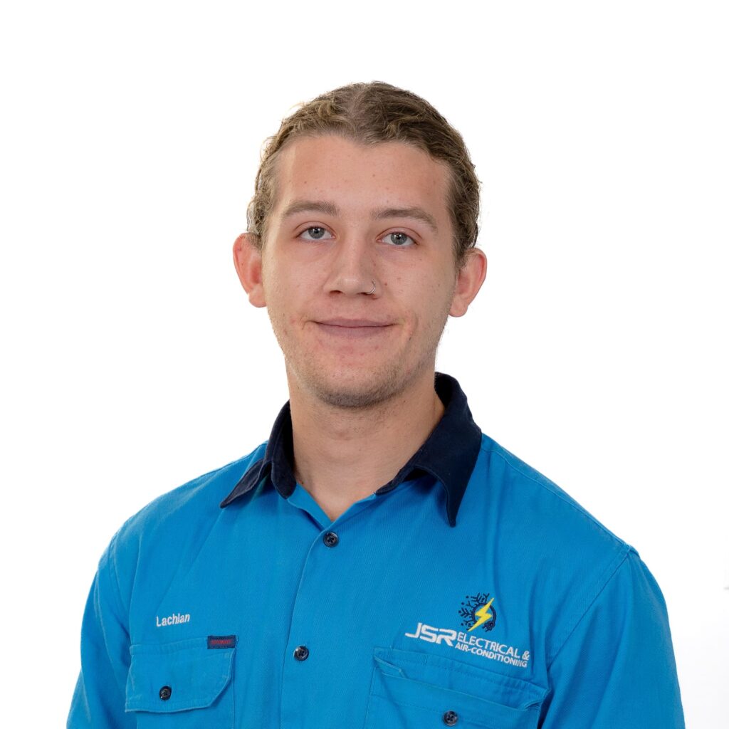 Man in blue electrical services shirt smiling at camera